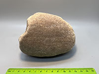 A beach cobble composed entirely of fine crystalline quartz and displays percussion marks on its surface.